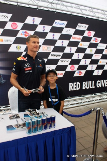 Kid poses with David Coulthard at Red Bull Speed Street Singapore 2011 at Orchard Road on 24 Apri 2011