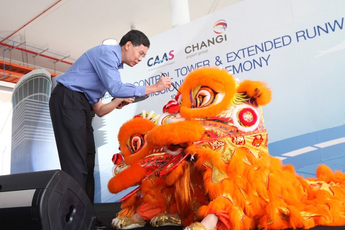 Mr Lui Tuck Yew, Minister for Transport and Second Minister for Foreign Affairs, dotting the eyes of the lions at a ceremony held to commission the use of the new control tower and extended runway at Seletar Airport.
