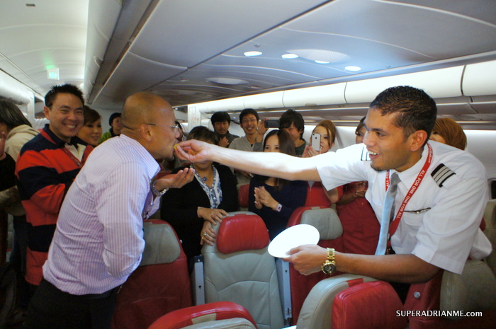 AirAsia X D7 535 2 Dec 2011 - Senior First Officer Raveen feeds CEO Azran Osman Rani a slice of his birthday cake